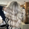 Cheveux longs et ondulés d'un blond polaire éclatant.