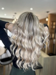 Cheveux longs et ondulés d'un blond polaire éclatant.