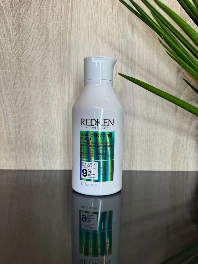 Redken Shampoing réparateur Boucles Acidic Bonding Curls pour cheveux bouclés et frisés. Hydrate, réduit les frisottis et renforce les boucles avec une formule vegan et sans silicone.