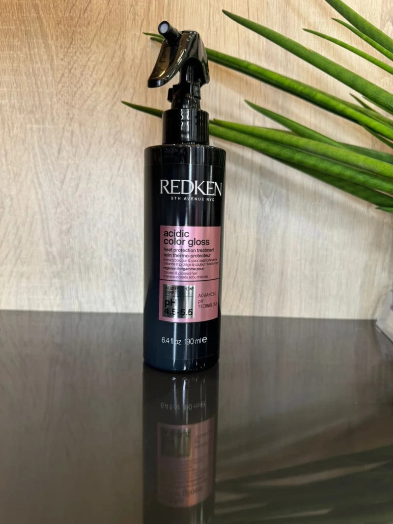 Redken Soin thermo protecteur Acidic Color Gloss pour cheveux colorés et décolorés, offrant protection jusqu’à 230°C, hydratation et brillance éclatante.