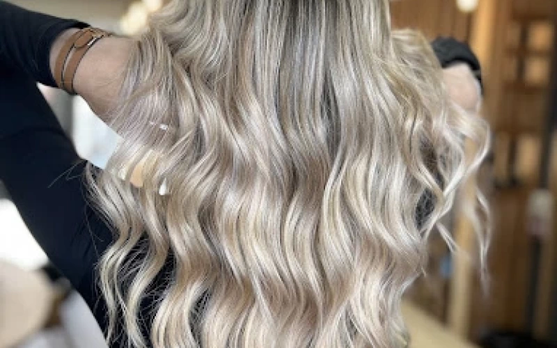 Cheveux longs et ondulés d'un blond polaire éclatant.